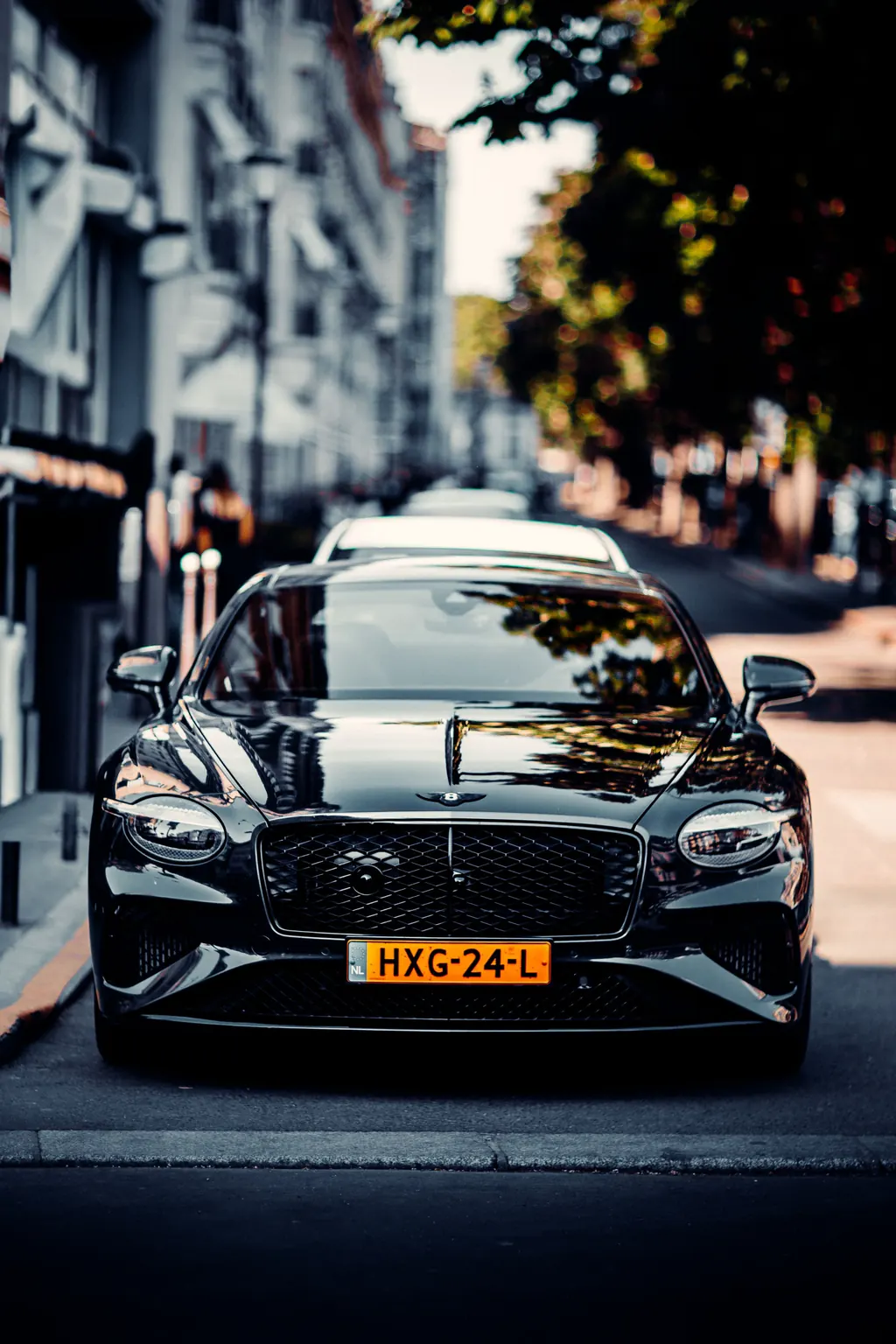 Front view of a polished black premium car on a city street